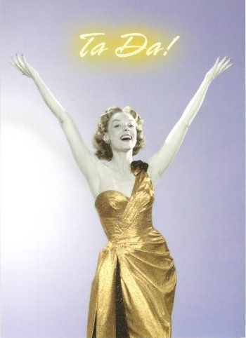 a woman in a gold/yellow dress exclaiming 'tada'